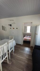 een kamer met een tafel en stoelen en een slaapkamer bij Casa quadra mar in Arroio do Silva