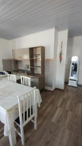 een woonkamer met een tafel en een keuken bij Casa quadra mar in Arroio do Silva