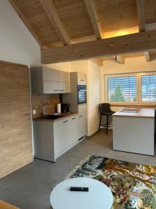 a kitchen with white cabinets and a table at Seerestaurant & Suiten Hayat in Steindorf am Ossiacher See