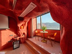 a room with a table and chairs and a large window at Xinchen B&B in Ge Dao