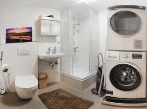 a bathroom with a washing machine and a shower at Nest76 in Karlsruhe +13 photos