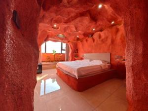 a bedroom with a bed in a rock wall at Xinchen B&B in Ge Dao
