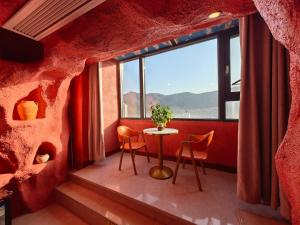 a room with a table and chairs and a window at Xinchen B&B in Ge Dao