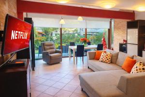 een woonkamer met een bank en een tv bij Villa Pineta Grande in Lignano Sabbiadoro