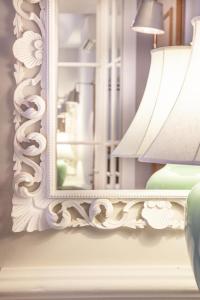 a mirror on a wall next to a lamp at Cellai Hotel Florence in Florence