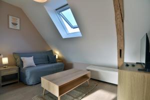 un soggiorno con un divano blu e una finestra di Les Trois Rois 6 - Centre Avranches ad Avranches