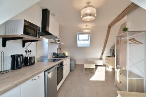 una cucina con mobili bianchi e un piano di lavoro di Les Trois Rois 6 - Centre Avranches ad Avranches