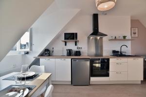 una cucina con mobili bianchi e un forno a piano cottura di Les Trois Rois 6 - Centre Avranches ad Avranches