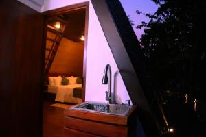 a bathroom with a sink in a room with a bed at Villa Anaa in Habaraduwa Central