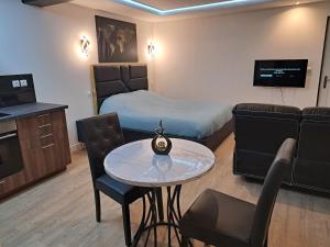 a bedroom with a bed and a table and a couch at La suite d'Isa in Lens