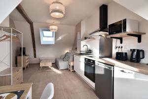 eine Küche mit Herd Top-Backofen neben einem Wohnzimmer in der Unterkunft Les Trois Rois 5 - Centre Avranches in Avranches + 4 Fotos