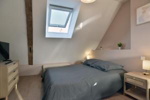 ein Schlafzimmer mit einem Bett und einem Fenster in der Unterkunft Les Trois Rois 5 - Centre Avranches in Avranches