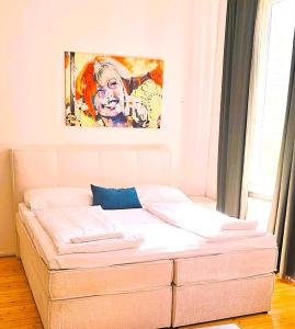 un letto in una stanza con un dipinto sul muro di Bahnhofstrasse a Klagenfurt