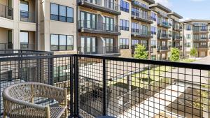 a balcony with two chairs and a building at Landing Apartments - The Quinn in Anna