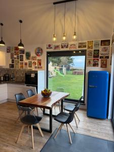 une cuisine avec une table et des chaises et un réfrigérateur bleu dans l'établissement BananaHouse, à Kruszwin