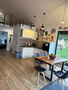 une cuisine et une salle à manger avec une table et des chaises en bois dans l'établissement BananaHouse, à Kruszwin