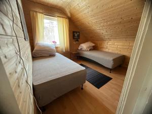 una piccola stanza con due letti e una finestra di Bestefarhuset a Hakkstabben