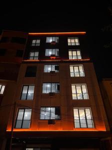 a tall building with lit windows at night at Bediroğlu apart in Arnavutköy +1 photo