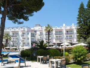 un hôtel avec des tables et des chaises devant un bâtiment dans l'établissement Halıcı Hotel Marmaris, à Marmaris