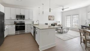 een keuken met witte kasten en een eiland in een kamer bij Landing Beautiful 3BD Yoga Studio Pool in Athens