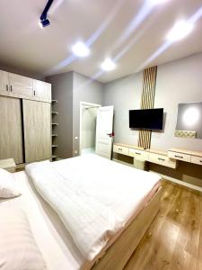 una camera da letto con un letto grande e una TV a schermo piatto di Eco Apartments a Yakkasaray