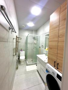 un bagno con doccia, WC e lavandino di Eco Apartments a Yakkasaray Altre 11 foto