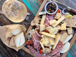 een dienblad met verschillende soorten eten en een glas wijn bij Ibis Lunel Petite Camargue in Lunel