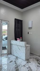 a room with a white wall with a window at Sasuka Inn Rusila in Marang