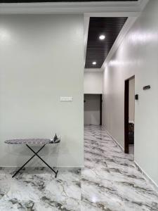 a hallway with a table in a room with marble floors at Sasuka Inn Rusila in Marang