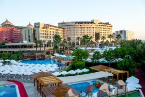 a resort with a pool and tables and chairs and buildings at Fame Residence Lara & Spa in Lara