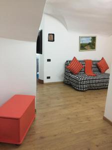 sala de estar con 2 sofás y reposapiés rojo en Le Grazie Maisons Genova, en Génova