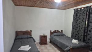 a bedroom with two beds and a night stand with towels at Complejo Casablanca Plottier in Plottier