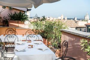 un tavolo con tavoli e sedie bianchi su un balcone di Hotel Concordia a Roma