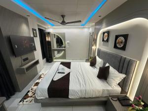 a bedroom with a large bed with blue lights on it at Hotel THE Vibes in Koba