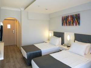 une chambre d'hôtel avec deux lits et un tableau au mur dans l'établissement Halıcı Hotel Marmaris, à Marmaris 29 autres photos