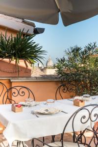 un tavolo bianco e sedie su un balcone di Hotel Concordia a Roma