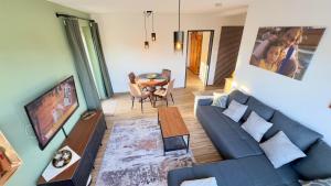 a living room with a blue couch and a table at SCHILLING stay&more in Wörgl