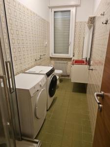 een badkamer met wasmachine en toilet bij Appartamento vicino lo stadio con garage in Piacenza