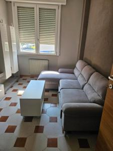 een woonkamer met een bank en een tafel bij Appartamento vicino lo stadio con garage in Piacenza +1 foto