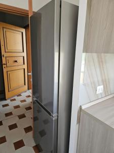 een roestvrijstalen koelkast in een keuken naast een deur bij Appartamento vicino lo stadio con garage in Piacenza