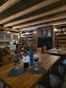 a wooden table with two glasses and a bottle of wine at Koppány Pines Rewild Escapes - Hungarian Village Vendeghaz in Koppányszántó