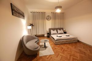 a living room with a couch and a chair and a bed at Naschpark Dream Apartments! in Vienna +59 photos