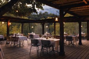 a restaurant with tables and chairs on a wooden deck at Hotel Restaurant & Spa E Caselle in Venaco