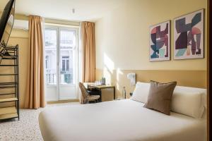 a hotel room with a bed and a desk at BYPILLOW The Citadel in Madrid