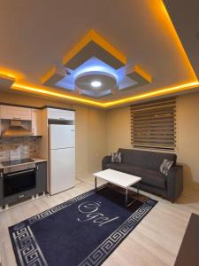 a living room with a couch and a table at Ögel Apart Otel in Sarıkamıs