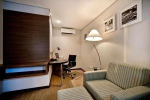 a living room with a couch and a desk in a room at Flat Radisson Hotel Belem in Belém +2 photos