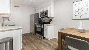 a small kitchen with a stove and a microwave at Landing Apartments - The Carlisle at Dunedin in Dunedin