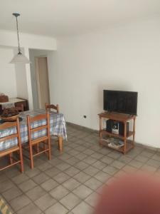 een woonkamer met een tafel en een televisie bij La amistad in Necochea