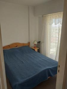 een slaapkamer met een blauw bed en een raam bij La amistad in Necochea
