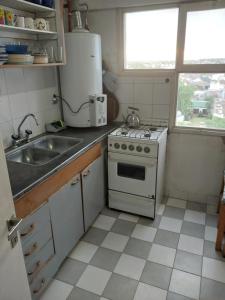 een kleine keuken met een fornuis en een spoelbak bij La amistad in Necochea